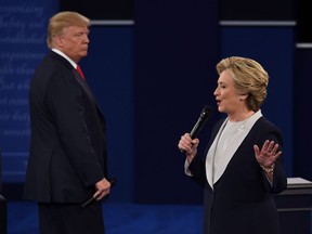 U.S. Democratic presidential candidate Hillary Clinton (R) speaks as US Republican presidential candidate Donald Trump listens during the second presidential debate at Washington University in St. Louis, Missouri, on October 9, 2016. /