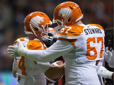 B.C. Lions' quarterback Travis Lulay, left, and Hunter Steward celebrate Lulay's touchdown against the Ottawa Redblacks during the first half of a CFL football game in Vancouver, B.C., on Saturday October 1, 2016.
