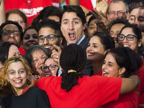 Prime Minister Justin Trudeau is swarmed by employees at the new Amazon Fulfillment Centre after he made an announcement in Brampton, Ont., on Thursday, October 20, 2016. THE CANADIAN PRESS/Nathan Denette ORG XMIT: NSD102