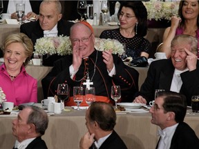 From left Democratic presidential nominee Hillary Clinton, Timothy Cardinal Dolan, Archbishop of New York, and Republican presidential nominee Donald Trump laugh during the Alfred E. Smith Memorial Foundation Dinner at Waldorf Astoria October 20, 2016 in New York, New York. /