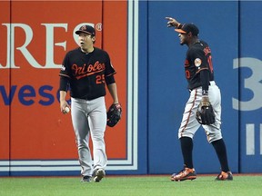 Hyun Soo Kim #25 of the Baltimore Orioles and Adam Jones #10 react in the seventh inning after a fan threw a beverage onto the field during the American League Wild Card game against the Toronto Blue Jays at Rogers Centre on October 4, 2016 in Toronto.