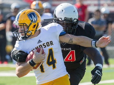 Windsor QB Casey Wright tries to avoid a tackle with Dan Omara in pursuit as the Carleton Ravens take on the Windsor Lancers in OUA football action at MNP Park on the Carleton University campus.