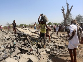 Yemenis make their way through rubble on October 8, 2016 next to a house that was hit the day before by a reported airstrike by Saudi-led coalition air-planes, killing a family, in Bajil in the western province of Houdieda. /