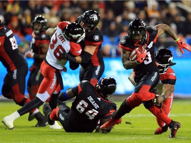TORONTO, ON - NOVEMBER 27:  Travon Van #3 of the Ottawa Redblacks is tripped up by Junior Turner #7 of the Calgary Stampeders during the first half of the 104th Grey Cup Championship Game at BMO Field on November 27, 2016 in Toronto, Canada.