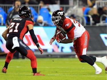 TORONTO, ON - NOVEMBER 27:  Jerome Messam #33 of the Calgary Stampeders runs the ball toward Mitchell White #21 of the Ottawa Redblacks during the first half of the 104th Grey Cup Championship Game at BMO Field on November 27, 2016 in Toronto, Canada.
