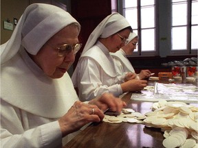 File photo of nuns from the cloistered  Servantes de Jesus-Marie packaging communion wafers the convent made for Ottawa-area Catholics
