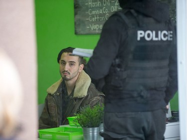 A man who went by the name "Curly" looks out of the window while being interrogated as Ottawa police conduct raids on a number of pot shops including Wee Medical on Rideau St. He later said he was released without charges as he was only a customer in the shop.