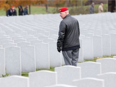 A veteran looks over the sea of headstones as families, veterans, and military personnel attend Remembrance Day ceremonies at Beechwood Cemetery.