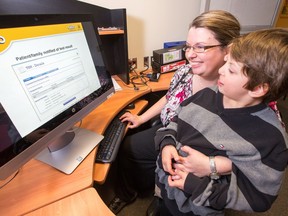 Angie Hamson with her son, Charlie Faithe, 7, checks out a MyChart page as CHEO unveils an electronic health records system that allows patients and their families to view lab and test results online, check appointment schedules, and read summaries of all medical visits.
