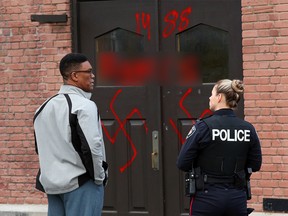 Hate graffiti on Parkdale United Church in Ottawa , November 18, 2016.  Photo by Jean Levac  ORG XMIT: 125374
Reverend Dr. Anthony Bailey with police officer.
Jean Levac