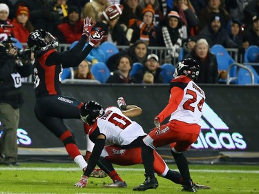 Brock Jensen of the Ottawa Redblacks makes a catch past Ciante Evans and Joe Burnet of the Calgary Stampeders during the 104th Grey Cup at BMO Field in Toronto, Ont. on Sunday November 27, 2016. Dave Abel/Toronto Sun/Postmedia Network