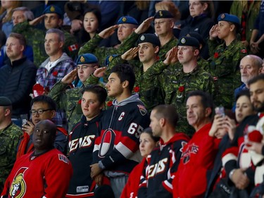 Canadian Forces members and Ottawa Senators fans stand at attention during the Canadian national anthem on the 13th annual Canadian Forces Appreciation Night at Canadian Tire Centre before taking on the Carolina Hurricanes on Tuesday November 1, 2016. Errol McGihon/Postmedia