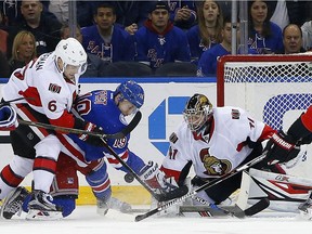 Ottawa Senators goaltender Craig Anderson (41) makes a save on a shot by New York Rangers' Jesper Fast (19) as Senators' Chris Wideman (6) helps out during the first period of an NHL hockey game in New York, Sunday, Nov. 27, 2016.