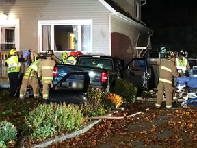 First responders work to free two occupants of a trucjk that smashed into a home in Vanier on Tuesday, Nov. 8
