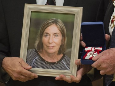 Governor General David Johnston holds the Order of Canada for Patricia Cranton as her brother John holds her picture during an Order of Canada ceremony at Rideau Hall in Ottawa, Thursday, November 17, 2016. Cranston passed away before her induction to the Order.