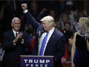 Republican presidential candidate Donald Trump acknowledges his supporters between vice presidential nominee, Indiana Gov. Mike Pence, left, and his daughter Ivanka, right, at a campaign rally, Monday, Nov. 7, 2016, in Manchester, N.H.