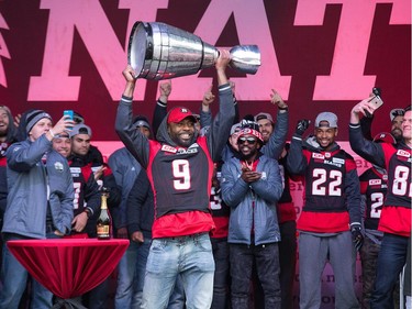 Ernest Jackson carries the Grey Cup on stage as the Ottawa Redblacks celebrate their Grey Cup victory with a parade down Bank St and a celebration at Lansdowne Park.