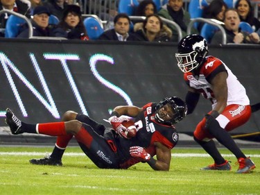 Ernest Jackson of the Ottawa Redblacks is taken down by Jamar Wall of the Calgary Stampeders during the 104th Grey Cup at BMO Field in Toronto, Ont. on Sunday November 27, 2016. Dave Abel/Toronto Sun/Postmedia Network