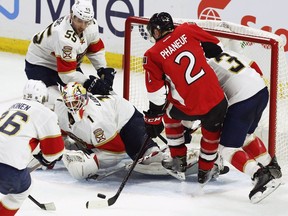 Florida Panthers goaltender Roberto Luongo keeps his eyes on the puck as his teammates converge on the Ottawa Senators' Dion Phanuef at the Canadian Tire Centre on Saturday, Nov. 19, 2016.
