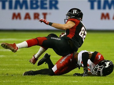 Greg Ellingson of the Ottawa Redblacks is upended by Joshua Bell of the Calgary Stampeders during the 104th Grey Cup at BMO Field in Toronto, Ont. on Sunday November 27, 2016. Dave Abel/Toronto Sun/Postmedia Network