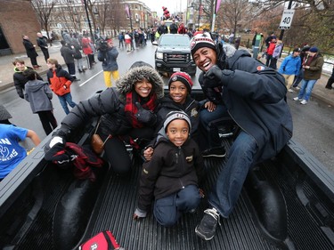 Ottawa RedBlacks Henry Burris and his wife Nicole and  their two boys having a great time with some fans on Bank Street during the 2016 Grey Cup Parade in Ottawa Tuesday Nov 29, 2016.   T