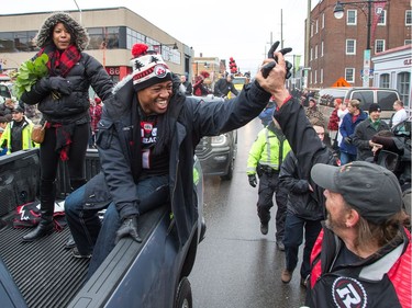 Henry Burris with his wife Nicole (L) greet fans along Bank St as the Ottawa Redblacks celebrate their Grey Cup victory with a parade down Bank St and a celebration at Lansdowne Park.