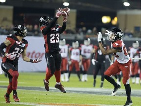 Ottawa Redblacks defensive back Forrest Hightower intercepts a pass intended for Calgary Stampeders slotback Kamar Jorden as Redblacks' Mitchell White (left) looks on during second quarter CFL Grey Cup action Sunday, November 27, 2016 in Toronto.