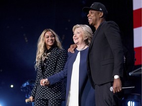 Democratic presidential candidate Hillary Clinton, center, appears on stage with artists Jay Z, right, and Beyonce, left, during a free concert at at the Wolstein Center in Cleveland, Friday, Nov. 4, 2016.