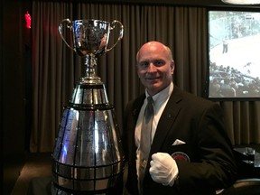 Jeff McWhinney, one of the "keepers" of the Grey Cup trophy, poses with the CFL championship trophy at a Toronto bar/restaurant during a 2016 Grey Cup week event on Wednesday, Nov. 23, 2016. Photo by Gord Holder, Postmedia News