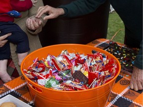 California Gov. Jerry Brown hands Jessica Minnihan a piece of Halloween candy for her daughter, Audrey, 8-months-old, in Sacramento, Calif., Monday, Oct. 31, 2016. In the spirit of Halloween, Brown and his wife, Anne Gust Brown passed out candy to those who passed by the Governor's Mansion.(AP Photo/Rich Pedroncelli) ORG XMIT: CARP103