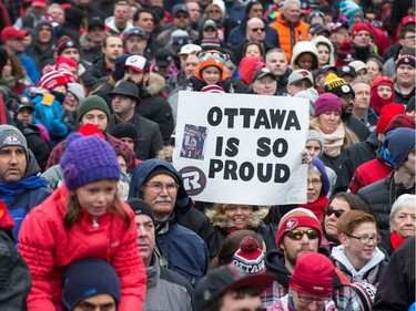 Julie Tyson Dunnigan holds up her sign that says "Ottawa is So Proud" as the Ottawa Redblacks celebrate their Grey Cup victory with a parade down Bank St and a celebration at Lansdowne Park.