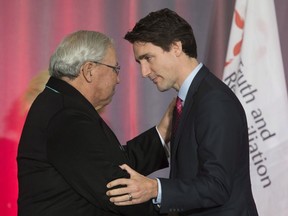 Commissioner Justice Murray Sinclair shakes hands with Prime Minister Justin Trudeau during the release of the final report of the Truth and Reconciliation commission is released, Tuesday December 15, 2015 in Ottawa.