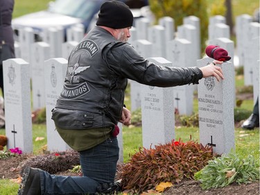 Ken Downton, a retired Warrant Officer who served as a parachute rigger, takes a moment at the grave site of his good friend Michael Hamilton who died in a training accident in 2009, as families, veterans, and military personnel attend Remembrance Day ceremonies at Beechwood Cemetery.