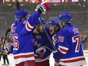 The New York Rangers' Matt Puempel, second from the right, celebrates with teammates Jimmy Vesey (26), Josh Jooris (86) and Brady Skjei (76) after scoring in his debut with the team on Friday, Nov. 25, 2016.