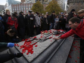 Members of the public lay poppies at the Tomb of the Unknown Soldier during Remembrance Day ceremonies in Ottawa on Friday, November 11, 2016.