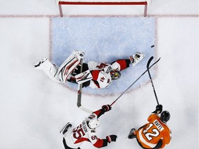 Philadelphia Flyers' Michael Raffl (12) scores a goal past Ottawa Senators' Craig Anderson (41) and Erik Karlsson (65) during the second period of an NHL hockey game, Tuesday, Nov. 15, 2016, in Philadelphia.