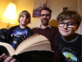 Oscar Alexander-Ramsay (L), Denny Alexander and Dominic Alexander-Ramsay (R) read before going to bed, November 16, 2016. Photo by Jean Levac