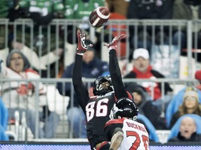 Ottawa Redblacks wide receiver Juron Criner (86) makes a catch as Calgary Stampeders defensive back Matt Bucknor (20) defends during fourth quarter CFL Grey Cup action Sunday, November 27, 2016 in Toronto.