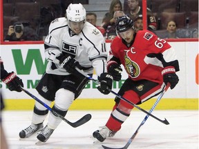 The Ottawa Senators' Erik Karlsson battles for the puck with Los Angeles Kings' Anze Kopitar.