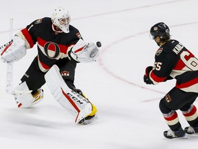 Ottawa Senators goalie Mike Condon (1) comes way out of  his net to glove a puck as Erik Karlsson looks on in play against the Vancouver Canucks at Canadian Tire Centre in Ottawa on Thursday November 3, 2016. Errol McGihon/Postmedia