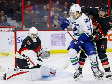 Ottawa Senators goalie Mike Condon (1) makes a save in his first game with his new team as Ottawa Senators defenseman Dion Phaneuf (2) checks Vancouver Canucks center Bo Horvat (53) at Canadian Tire Centre in Ottawa on Thursday November 3, 2016. Errol McGihon/Postmedia