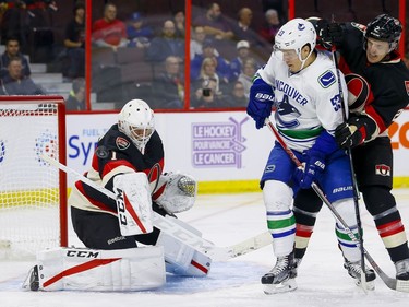 Ottawa Senators goalie Mike Condon (1) makes a save in his first game with his new team as Ottawa Senators defenseman Dion Phaneuf (2) checks Vancouver Canucks center Bo Horvat (53) at Canadian Tire Centre in Ottawa on Thursday November 3, 2016. Errol McGihon/Postmedia