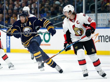 Kyle Okposo #21 of the Buffalo Sabres skates as Erik Karlsson #65 of the Ottawa Senators looks on during the second period at the KeyBank Center on November 9, 2016 in Buffalo, New York.