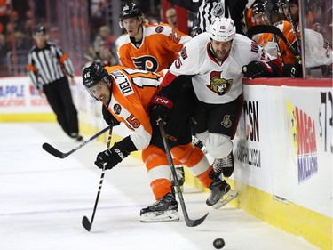 Zack Smith #15 of the Ottawa Senators (R) and Michael Del Zotto #15 of the Philadelphia Flyers collide as they battle for the puck during the first period at Wells Fargo Center on November 15, 2016 in Philadelphia, Pennsylvania.
