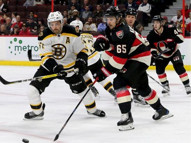 Ottawa's Erik Karlsson (right) gets to the puck just ahead of Boston's Patrice Bergeron in their end during third-period action of the Ottawa Senators matchup against the Boston Bruins Thursday (Nov.4, 2016) at Canadian Tire Centre in Ottawa.