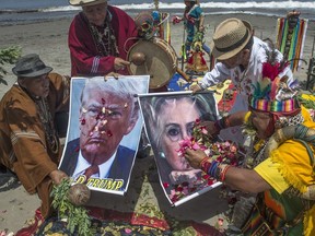 Shamans perform a ritual of predictions for the election with posters of presidential candidates Donald Trump and Hilary Clinton at the Agua Dulce beach in Lima.