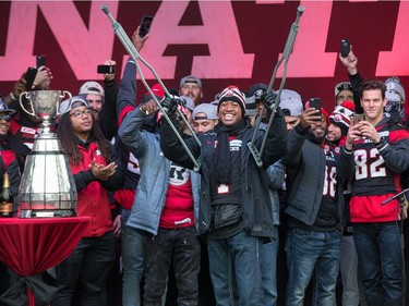 Quarterback Henry Burris acknowledges appal use from the crowd by raising his crutches as the Ottawa Redblacks celebrate their Grey Cup victory with a parade down Bank St and a celebration at Lansdowne Park.