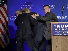 Secret Service agents rush Republican presidential candidate Donald Trump off the stage at a campaign rally in Reno, Nev., on Saturday, Nov. 5, 2016.