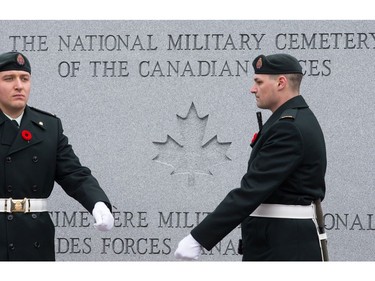 Soldiers march off from their posts as families, veterans, and military personnel attend Remembrance Day ceremonies at Beechwood Cemetery.