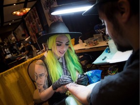 Gabrielle Munger from Addik Tattoo shop works on a client's tattoo on his arm during the Ottawa Gatineau Tattoo Expo at the Hilton Lac-Leamy.